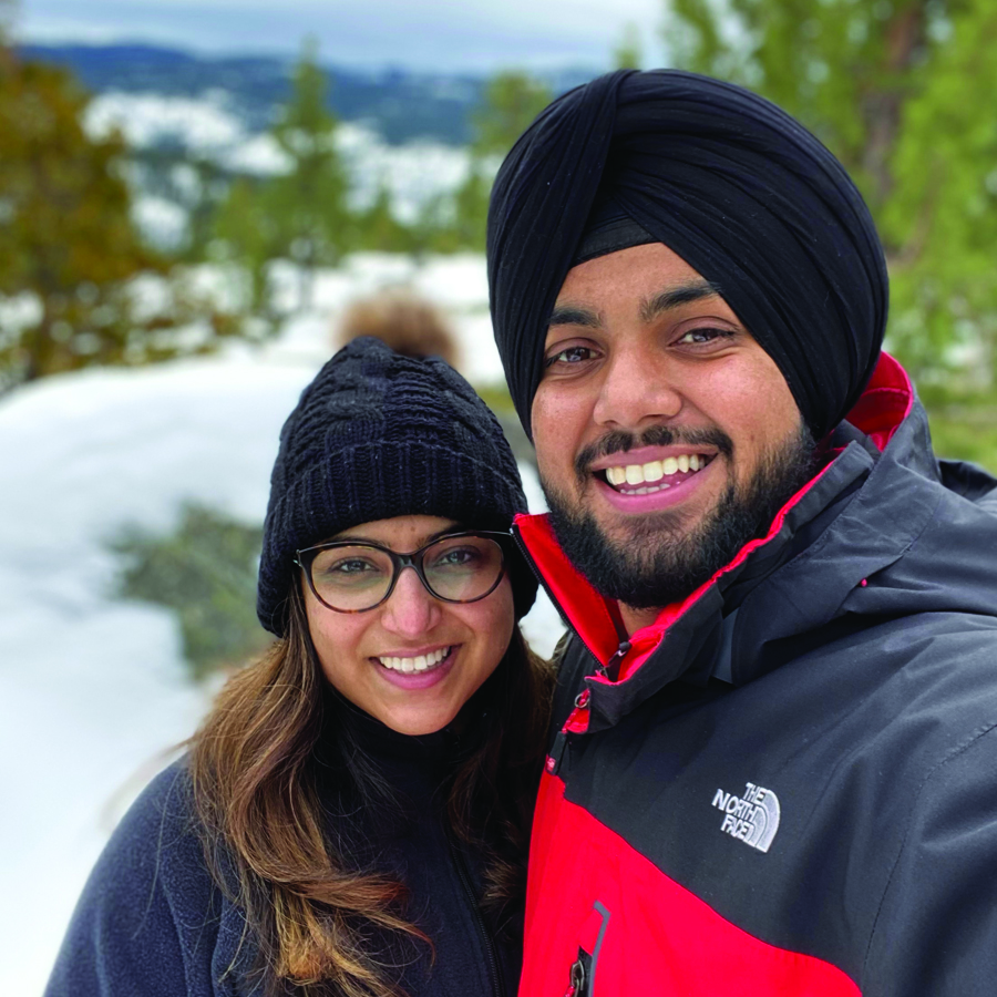 Two adults stand in a snowy landscape.