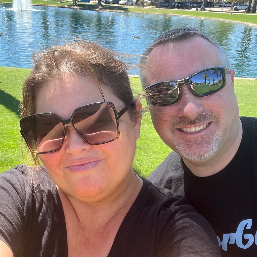 Photo of Eileen Harte and another adult near a pond.