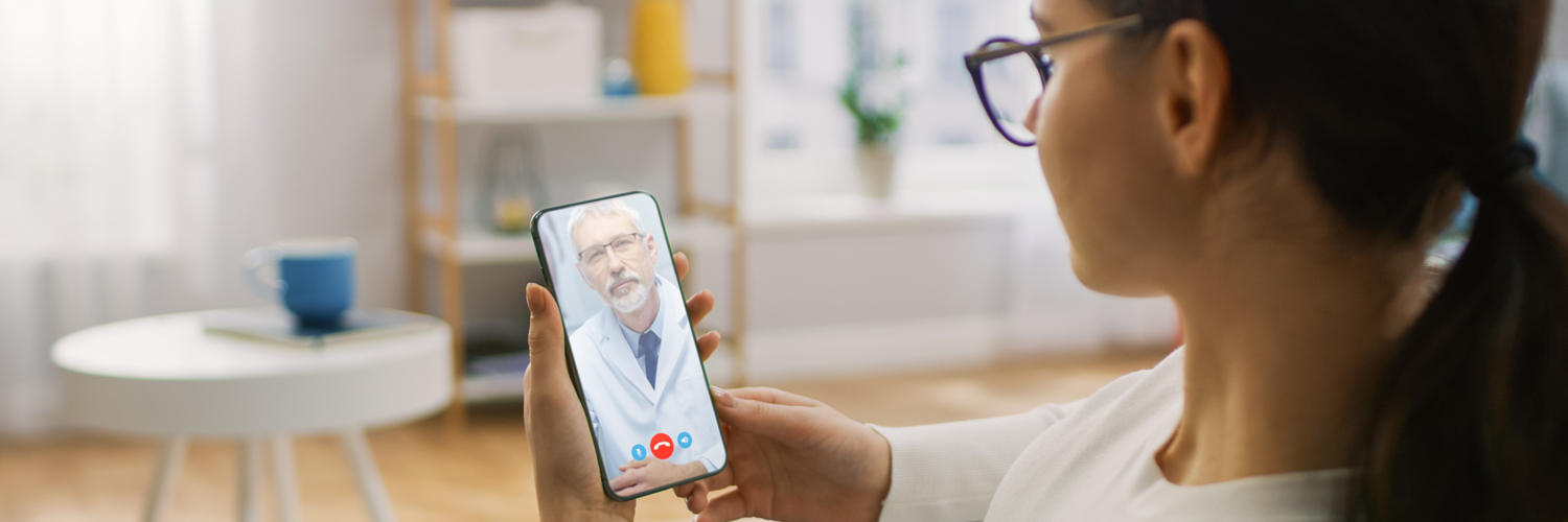 An adult consults with a caregiver on a mobile device.