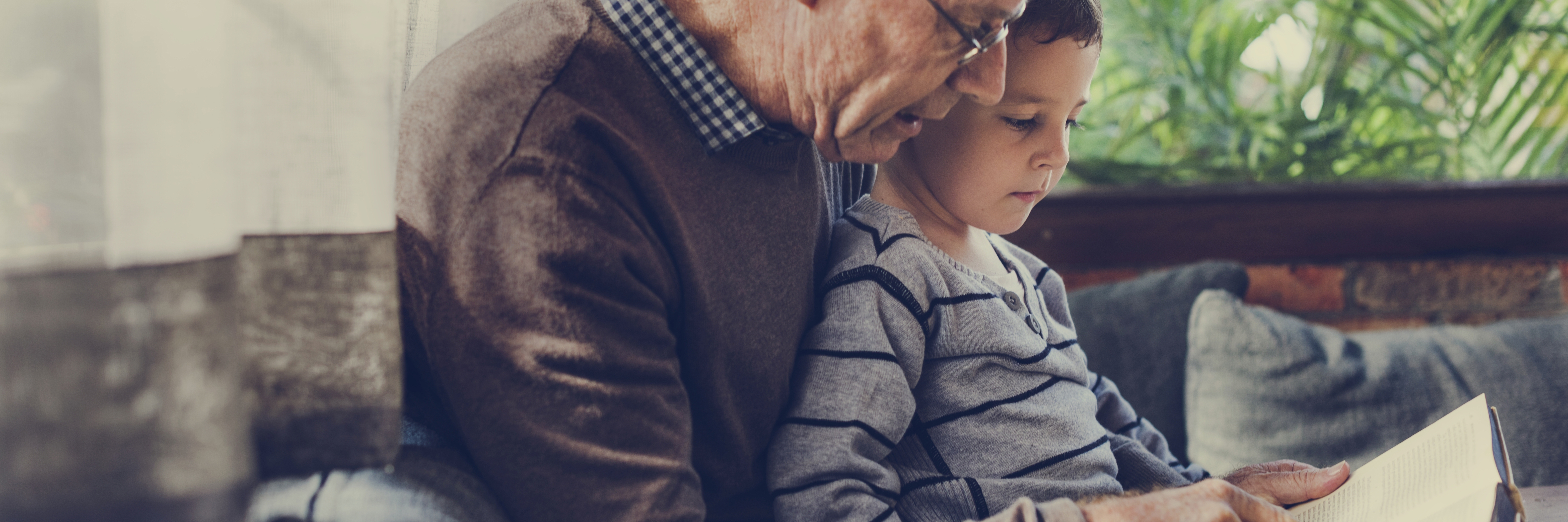 An adult reads to a child from a book.