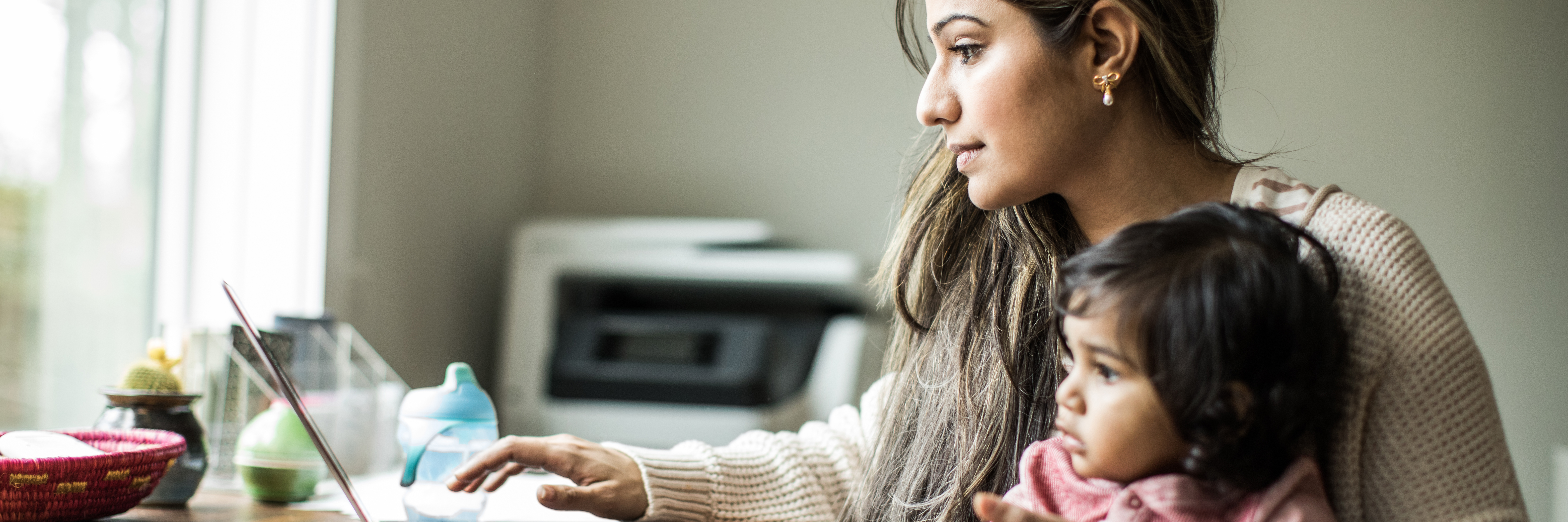 An adult and child look at a laptop computer.